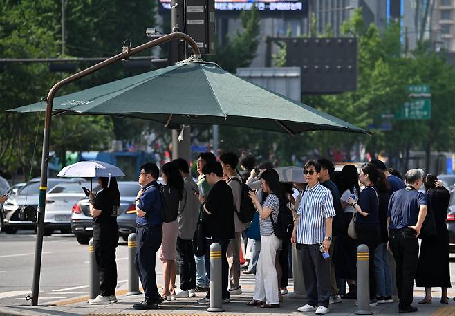 서울 종로구 세종대로 사거리에서 시민들이 그늘막에 모여 뜨거운 햇살을 피하고 있다. 임세준 기자