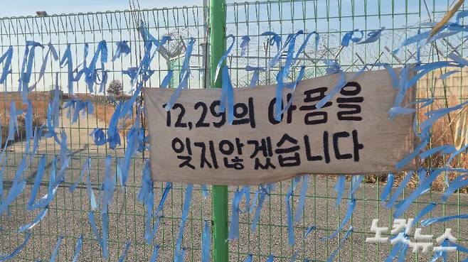 무안국제공항 활주로 인근에는 파란 리본과 '아픔을 잊지 않겠다'는 문구가 젹힌 천이 달려있다. 한아름 기자