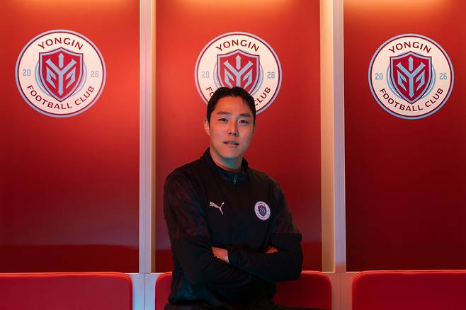 용인 엠블럼 앞에서 포즈를 취하는 K리그 베테랑 골키퍼 황성민. /사진=용인FC 제공