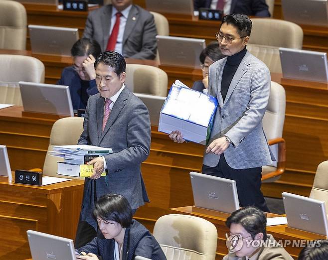 '내란전담재판부법' 무제한 반대 토론 나서는 장동혁 대표 (서울=연합뉴스) 황광모 기자 = 국민의힘 장동혁 대표(앞)가 22일 국회에서 열린 12월 임시국회 본회의에 내란전담재판부 법이 상정되자 무제한 반대 토론(필리버스터)을 하기 위해 자료를 들고 발언대로 이동하고 있다. 2025.12.22 hkmpooh@yna.co.kr