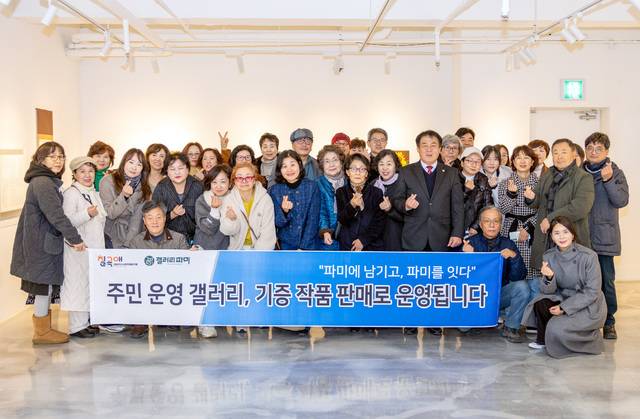 22일 칠곡군 왜관읍 갤러리 파미에서 열린 기증 작품 판매전 '파미에 남기고, 파미를 잇다'오프닝 행사에서 참여 작가들과 칠곡군 관계자들이 기념 촬영을 하고 있다. 칠곡군 제공