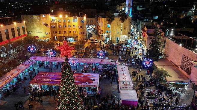 14일(현지시간) 팔레스타인 서안지구 베들레헴에서 열린 크리스마스 퍼레이드가 벌어진 예수 탄생 교회 근처 마구간 광장의 크리스마스 시장 2025.12.14. ⓒ 로이터=뉴스1 ⓒ News1 이정환 기자