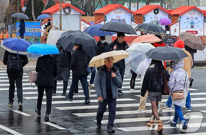 크리스마스 이브를 앞두고 진눈깨비가 내린 23일 서울 종로구 광화문광장에서 시민들이 발걸음을 재촉하고 있다. 2025.12.23/뉴스1 ⓒ News1 이호윤 기자