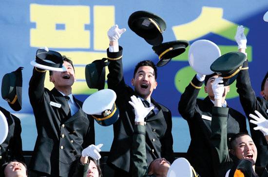 임관식을 마친 이지호 소위(가운데)가 동료들과 모자를 벗어던지며 환하게 웃고 있다.