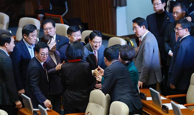 Rep. Jang Dong-hyeok, leader of the main opposition People Power Party, leaves the National Assembly as he receives encouragement from fellow lawmakers after setting a new record for the longest-ever filibuster on Tuesday. (Yonhap)