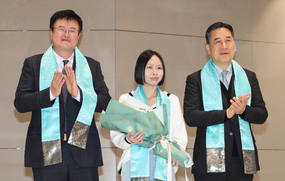 Second Vice Minister of Culture, Sports and Tourism Kim Dae-hyun, left, and Sharmaine Lee, center, the 18.5 millionth tourist to Korea who is from Singapore, center, pose for a photo at Terminal 2 of Incheon International Airport on Tuesday to celebrate a record high in annual inbound tourism to Korea. [KOREA TOURISM ORGANIZATION]
