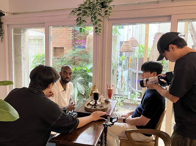 Jason Addy talks with the producers of Daegu Metropolitan City's official YouTube channel at a cafe. [JASON ADDY, HWANG IN-SEON]