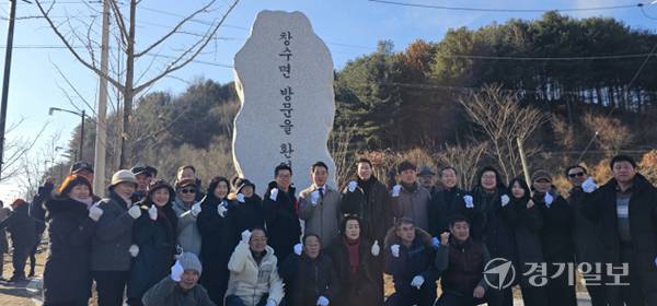 창수면 마을 가는 길 표지석 건립 기념 제막식에서 참석자들이 표지석을 배경으로 기념촬영을 하고 있다. 손지영기자