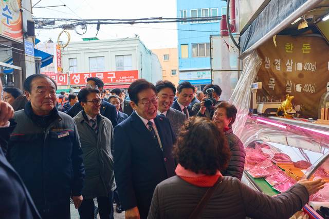 이재명 대통령이 23일 해양수산부 청사에서 국무회의를 마친 뒤 부산 부산진구 부전시장을 찾아 상인들과 이야기를 나누고 있다. 대통령실 제공