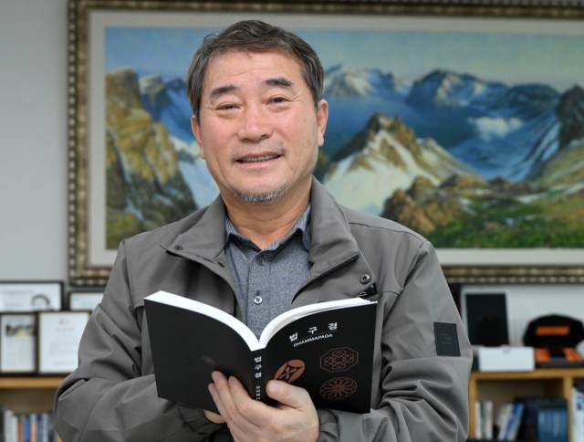 남민우 다산그룹 회장이 경기 성남시 다산그룹 본사에서 진행된 인터뷰에서 최근 출간한 ‘법구경’ 편역본을 들고 포즈를 취하고 있다. 성남=성형주 기자