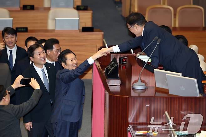 정청래 더불어민주당 대표가 23일 서울 여의도 국회에서 열린 제430회국회(임시회) 제2차 본회의에서 정보통신망 이용촉진 및 정보보호 등에 관한 법률 일부개정법률안(대안) 수정안에 대한 무제한 토론(필리버스터) 종결동의의 건 투표를 하고 우원식 국회의장과 악수하고 있다. 2025.12.24/뉴스1 ⓒ News1 이승배 기자