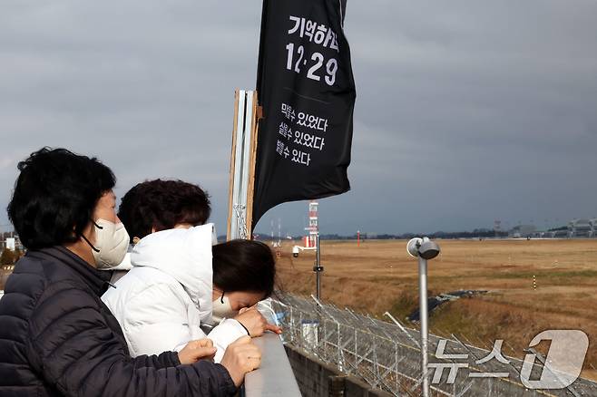 12·29 제주항공 여객기 참사 1주기를 앞둔 24일 전남 무안국제공항에서 유족들이 공항 활주로를 바라보며 눈물짓고 있다. ⓒ News1 박지현 기자