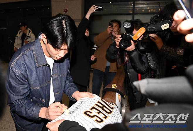메이저리그 샌디에이고 파드리스와 입단 계약을 맺은 송성문이 23일 인천국제공항을 통해 귀국한 뒤 팬의 모자와 유니폼에 사인을 하고 있다. 인천공항=허상욱 기자wook@sportschosun.com/2025.12.23/