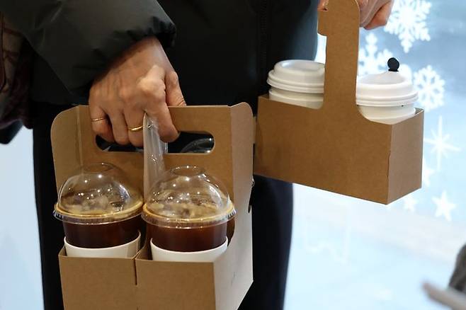 서울 시내의 한 카페에서 고객이 일회용 컵에 담긴 커피를 들고 가고 있다.ⓒ뉴시스