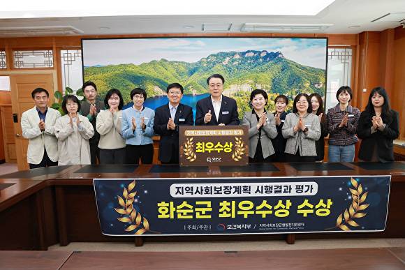 전남 화순군 관계자들이 지역사회보장계획 시행결과 평가 최우수상 수상 관련 현수막과 상패를 들고 있다. [사진=화순군]