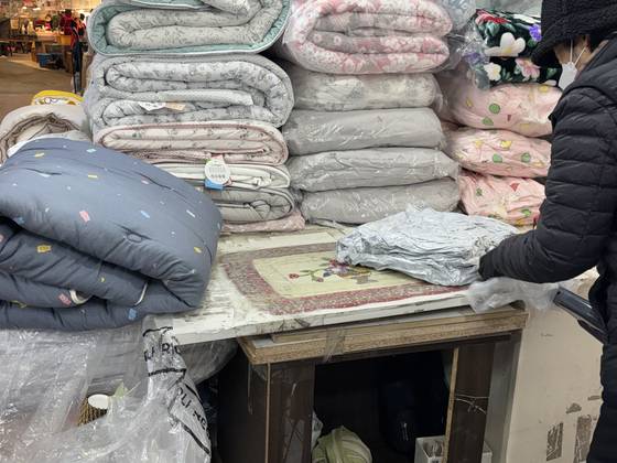 서울 종로구 광장시장의 한 이불 가게에서 직원이 이불을 진공 압축해 포장하고 있다. 곽주영 기자