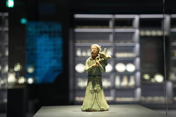 국립광주박물관 안에 새로 개관한 도자문화관 1층 ‘신안해저 도자 전시실’ 전경. 전남 신안 앞바다에서 발굴된 14세기 신안선 출수 도자기 6500점이 각양각색의 맵시를 뽐낸다. 사진은 신안선 출수 청자 '여인'(높이 19.7㎝). 여인이 어깨 위에 연꽃을 얹고, 두 손으로 연잎 가지를 잡고 있는 형상인데 연잎 가운데 기다란 대롱이 솟아 있다. 대롱은 초를 꽂는 촛대 역할을 했던 것으로 보인다.사진 국립광주박물관