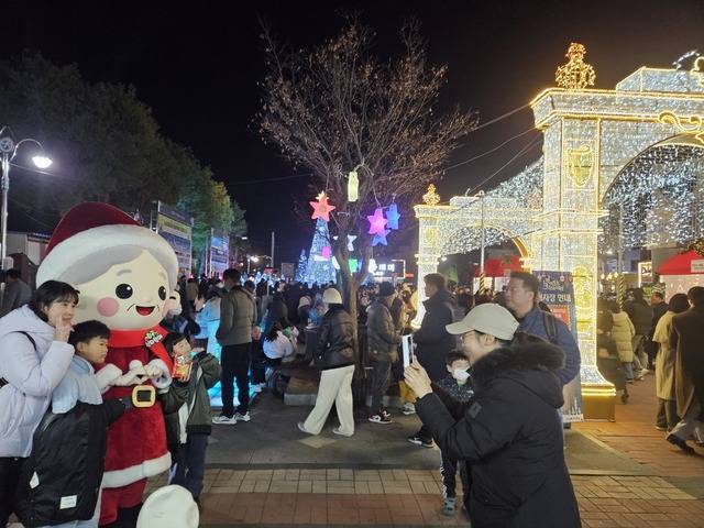 칠곡군이 크리스마스를 기념해 왜관역 광장에서 운영한 '럭키칠곡 크리스마스 마켓'에' 방문한 관광객들이 '칠곡산타할매'와 기념사진을 찍고 있다. 칠곡군 제공