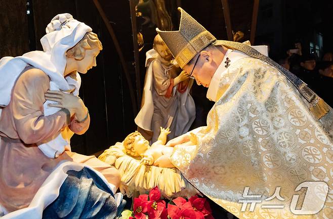 천주교 서울대교구장 정순택 대주교가 성탄절인 25일 새벽 서울 중구 명동대성당 앞마당에서 아기 예수를 말 구유에 안치하는 '구유 예절' 의식을 행하고 있다.(공동취재) 2025.12.25/뉴스1 ⓒ News1 구윤성 기자