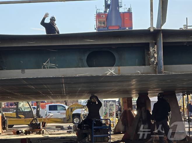 지난 22일(현지시간) 미국 펜실베이니아주 필라델피아에 위치한 한화필리조선소에서 작업 중이던 근로자가 취재진을 향해 손을 들어 인사하고 있다. 2025.12.25. ⓒ News1 류정민 특파원