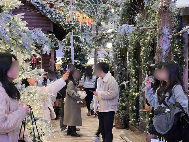 23일 더현대 서울 5층에 위치한 크리스마스 연출 공간 '해리의 크리스마스 공방'에서 방문객들이 인증 사진을 찍고 있다. 사진=김현지 기자