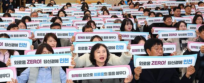 Participants at a launching ceremony for a local community task force to combat loneliness hold up slogans at Incheon City Hall in Incheon on Dec. 11. [YONHAP]