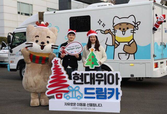 현대위아 직원이 지난 23일 사회복지기관 10곳에 기증하는 ‘현대위아 드림카’ 앞에서 포즈를 취하고 있다. 현대위아 제공