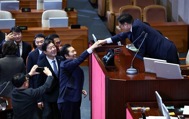 우원식(오른쪽) 국회의장과 정청래 더불어민주당 대표가 24일 국회 본회의장에서 전날 상정된 정보통신망법 개정안에 대한 필리버스터(무제한 토론) 종결 투표를 마친 뒤 악수하고 있다. 뉴시스