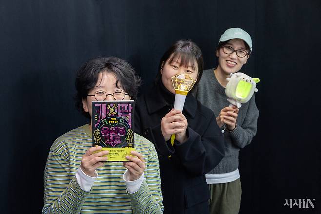 케이팝 팬이자 책 <케이팝 응원봉 걸스>를 쓴 작가 구구(왼쪽부터), 일석, 희주씨가 응원봉과 책을 들고 포즈를 취하고 있다. ⓒ시사IN 신선영