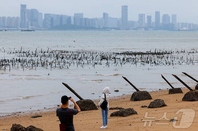 관광객이 대만 진먼에서 중국 샤먼을 배경으로 촬영을 하고 있다. 2025.10.20 ⓒ 로이터=뉴스1 ⓒ News1 정은지 특파원