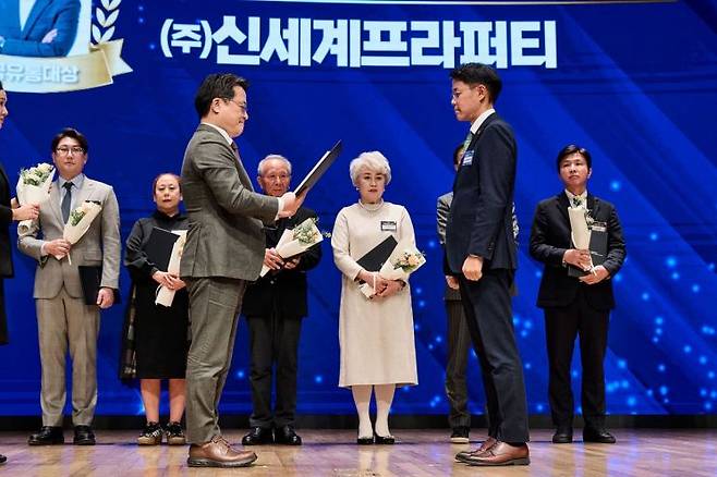 신동우 신세계프라퍼티 지원본부장(앞줄 오른쪽)이 '제30회 한국유통대상' 시상식에서 유통산업 상생·협력 문화확산 유공 부문 산업통상부장관 표창을 수상하고 있다. 신세계프라퍼티 제공