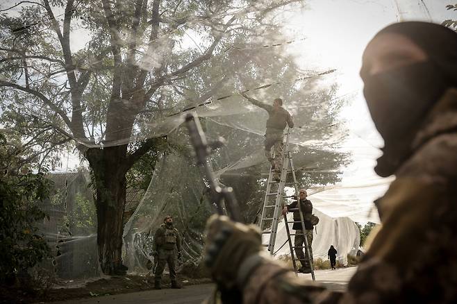 2025년 9월 19일 우크라이나 도네츠크 지역 최전방 마을에서 우크라이나 병사들이 도로 위에 드론 방지망을 설치하고 있다. /로이터 연합