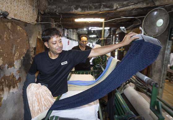 방글라데시에서 귀화한 김러셀씨가 서울 종로구 ‘고려주름’ 공장에서 자신이 만든 원단 제품을 들어 보이고 있다. 오른쪽은 김복환 사장. 김상선 기자