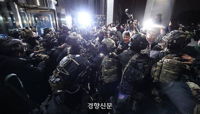 지난해 12월 3일 윤석열 대통령이 불법 계엄을 선포한 후 자정을 넘긴 4일 새벽 서울 여의도 국회의사당에 도착한 무장군인들이 국회 본청 진입을 시도하자 국회 직원 등이 격렬히 막아서고 있다. 성동훈 기자