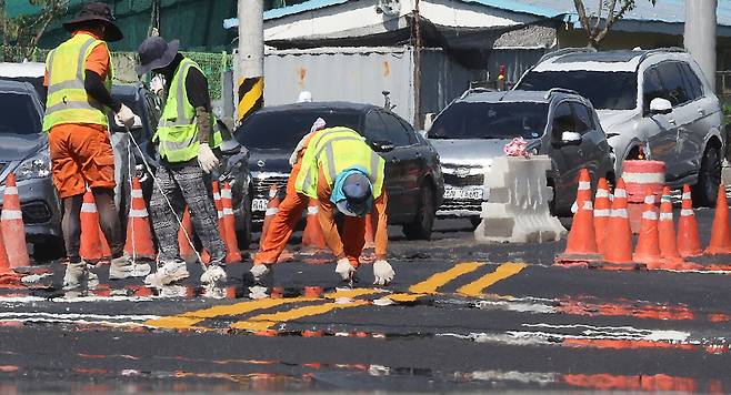 7월31일 노동자들이 달궈진 도로에서 차선 도색 작업을 하고 있다. ⓒ연합뉴스