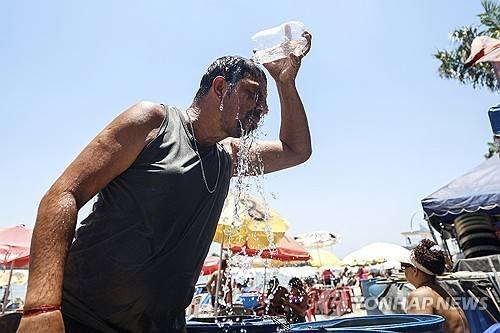 머리에 물 끼얹는 브라질 리우데자네이루 주민 (리우데자네이루 EPA=연합뉴스 재판매 및 DB금지)
