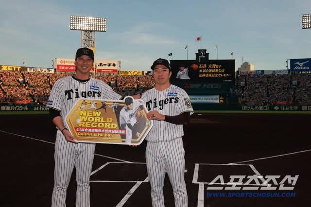 連続無失点記録を樹立し、藤川監督（左）と座る石井選手。写真撮影＝阪神タイガースSNS