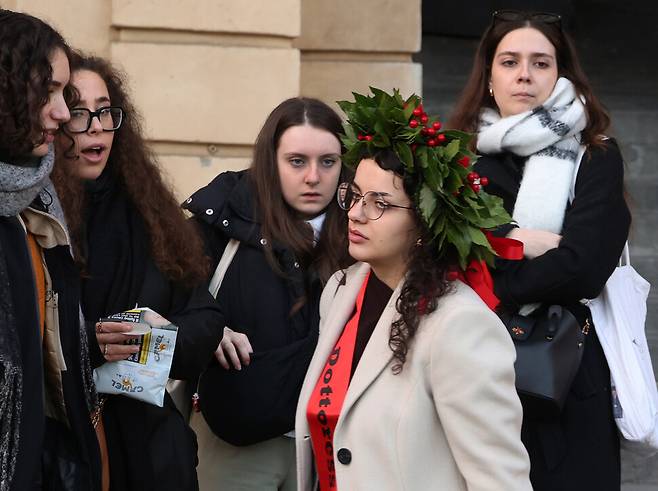 한 박사과정 졸업생이 월계관을 쓴 채 12월10일 시에나의 캄포 광장에서 친구들의 축하를 받고 있다.