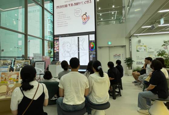 지난 9월 12일 부산 연제구 연제만화도서관에서 안나보니따 작가의 라이브 드로잉쇼가 진행되고 있다. 작가가 태블릿에 그리는 그림이 곧장 대형 스크린에 나타나 만화가 지망생 등에게 인기 있는 프로그램이다. 사진 부산 연제구
