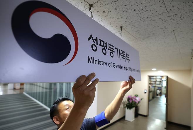 An employee fixes the plaque for the Ministry of Gender Equality and Family at the government complex in Jongno District, central Seoul, on Sept. 30. [NEWS1]