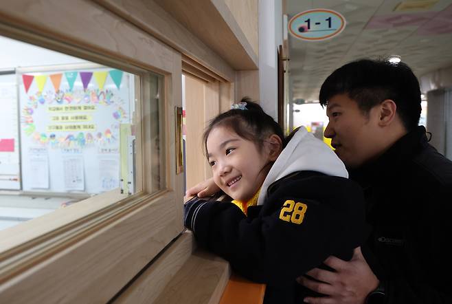 A child and her father visit the child's new classroom at an elementary school in Suwon, Gyeonggi, on Dec. 23. [NEWS1]