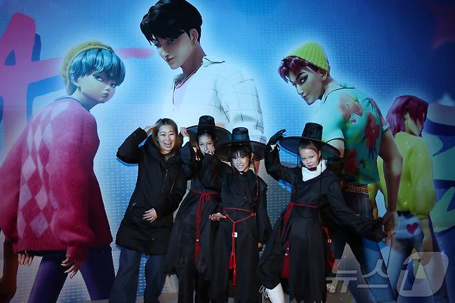 경기 용인시 에버랜드 내 케이팝 데몬 헌터스 팝업존에서 메기 강(Maggie Kang) 감독(왼쪽)이 저승사자 의상을 차려 입은 관람객들과 함께 기념촬영하고 있다. ⓒ News1 장수영 기자