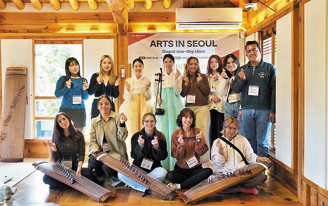 서울 아트투어 삼청 A코스에 참가한 외국인들이 등산센터 북악산점 내 한옥라운지에서 전통악기를 배운 후 기념촬영하고 있다.