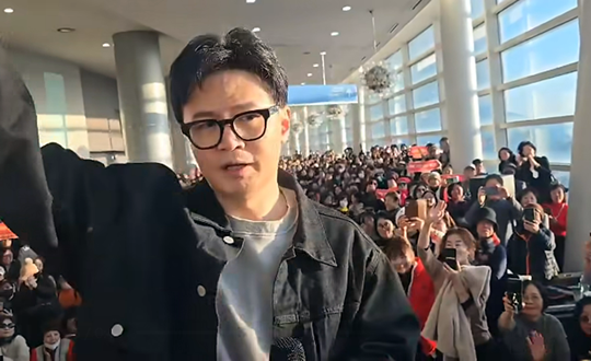 한동훈 국민의힘 전 당대표가 지난 12월 21일 오후 경기 고양시 일산 킨텍스에서 지지자 2000여명이 참석하는 토크콘서트 개최에 앞서, 입장권 없이 행사장 밖 로비에서 대기 중이던 지지자들과 만나 인사하고 있다.<김종혁 국민의힘 경기 고양병 당협위원장 페이스북 게재 영상 갈무리>