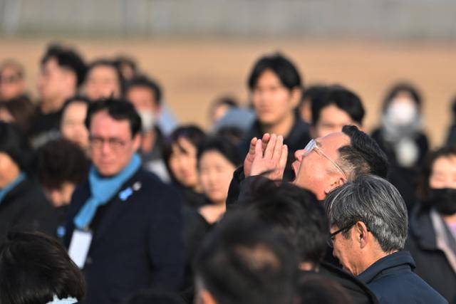 12·29 제주항공 여객기 참사 1주기인 29일 전남 무안국제공항 활주로 콘크리트 둔덕 주변에서 한 참사 유가족이 희생자들을 기리며 하늘을 향해 소리치고 있다. 무안=뉴시스