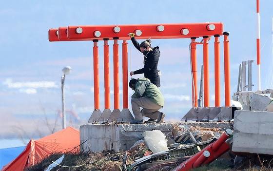 지난 1월 2일 오전 전남 무안군 무안국제공항 제주항공 여객기 참사 현장에서 미국 합동조사팀 관계자들이 콘크리트 둔덕에 올라 로컬라이저 길이를 재고 있다. 연합뉴스