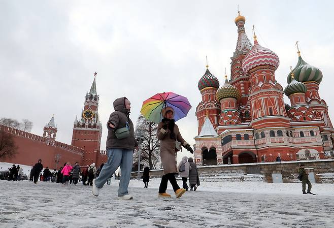 26일(현지시간) 러시아 모스크바에서 눈이 내리는 가운데 시민들이 크렘린 인근을 지나가고 있다. EPA연합뉴스