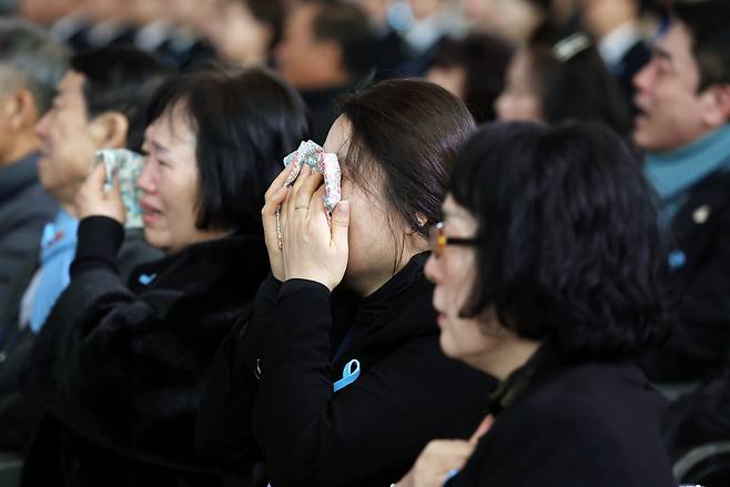 Bereaved families of those who died in the Dec. 29, 2024, air crash at the Muan International Airport  wipe their tears at an event to commemrate the crash held Monday at the airport. (Yonhap)