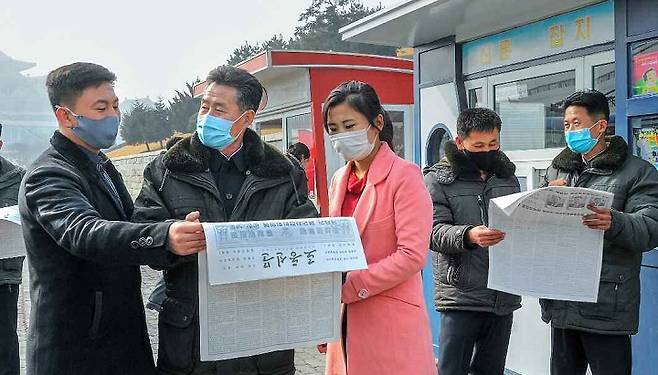 노동신문을 보는 북한 인민들 [사진=뉴시스]