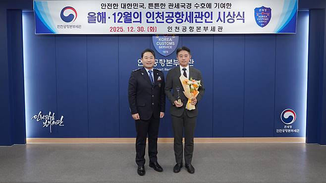 2025년 '12월의 인천공항세관인'으로 선정된 김선욱 주무관(왼쪽은 박헌 인천공항본부세관장) [사진=인천공항세관]